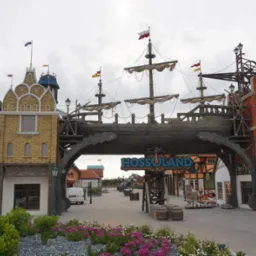 Fascynująca brama do Hossoland, stylizowana na średniowieczne miasto portowe z elementami statku, wież i flag. Kolorowe budynki i kwiaty w tle.