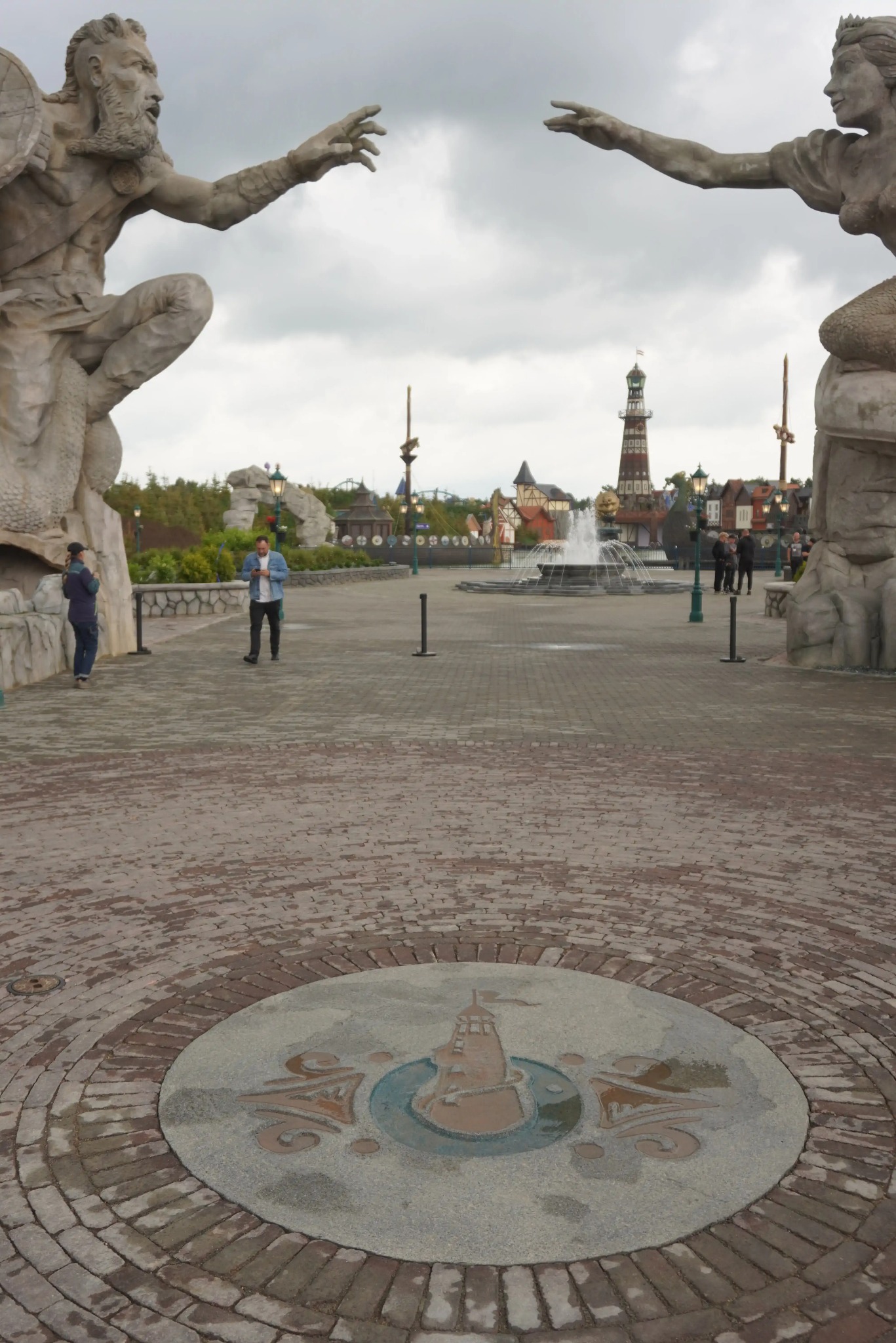 Tematyczny park rozrywki: centralny plac z fontanną, latarnią morską i rzeźbami mitologicznych postaci. Brukowana nawierzchnia z dekoracyjnym elementem centralnym.