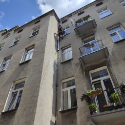 Montaż rur spustowych na kamienicy.