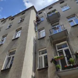 Montaż rur spustowych na kamienicy.