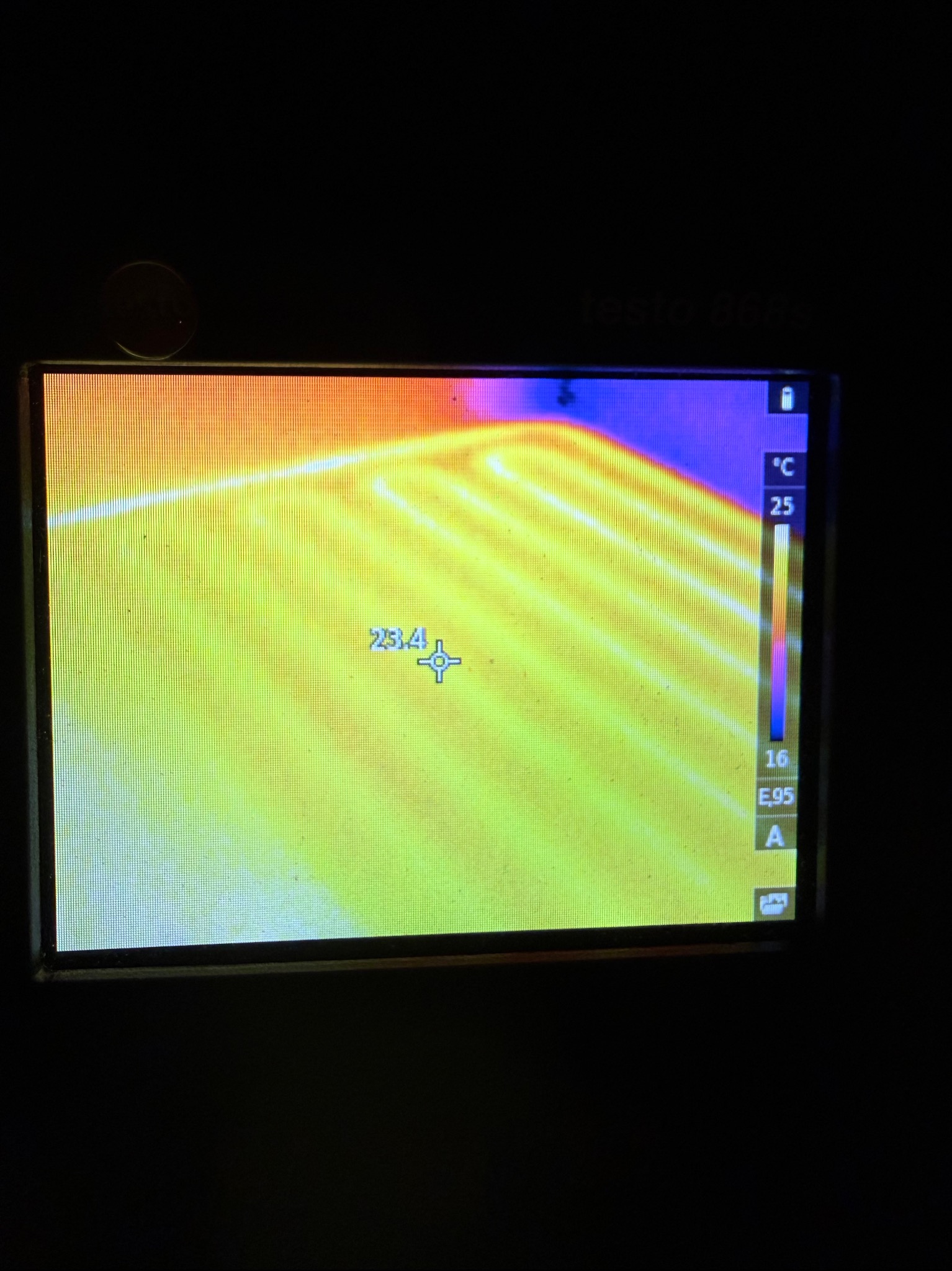 Ekran kamery termowizyjnej z widocznym rozkładem temperatur, wskazujący na potencjalne straty ciepła. Temperatura oznaczona na 23.4 stopnie Celsjusza.