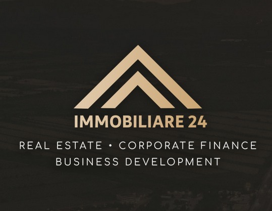 Eleganckie logo 'Immobiliare 24' w odcieniach złota na ciemnym tle. Napis 'Real Estate, Corporate Finance, Business Development' pod logotypem.