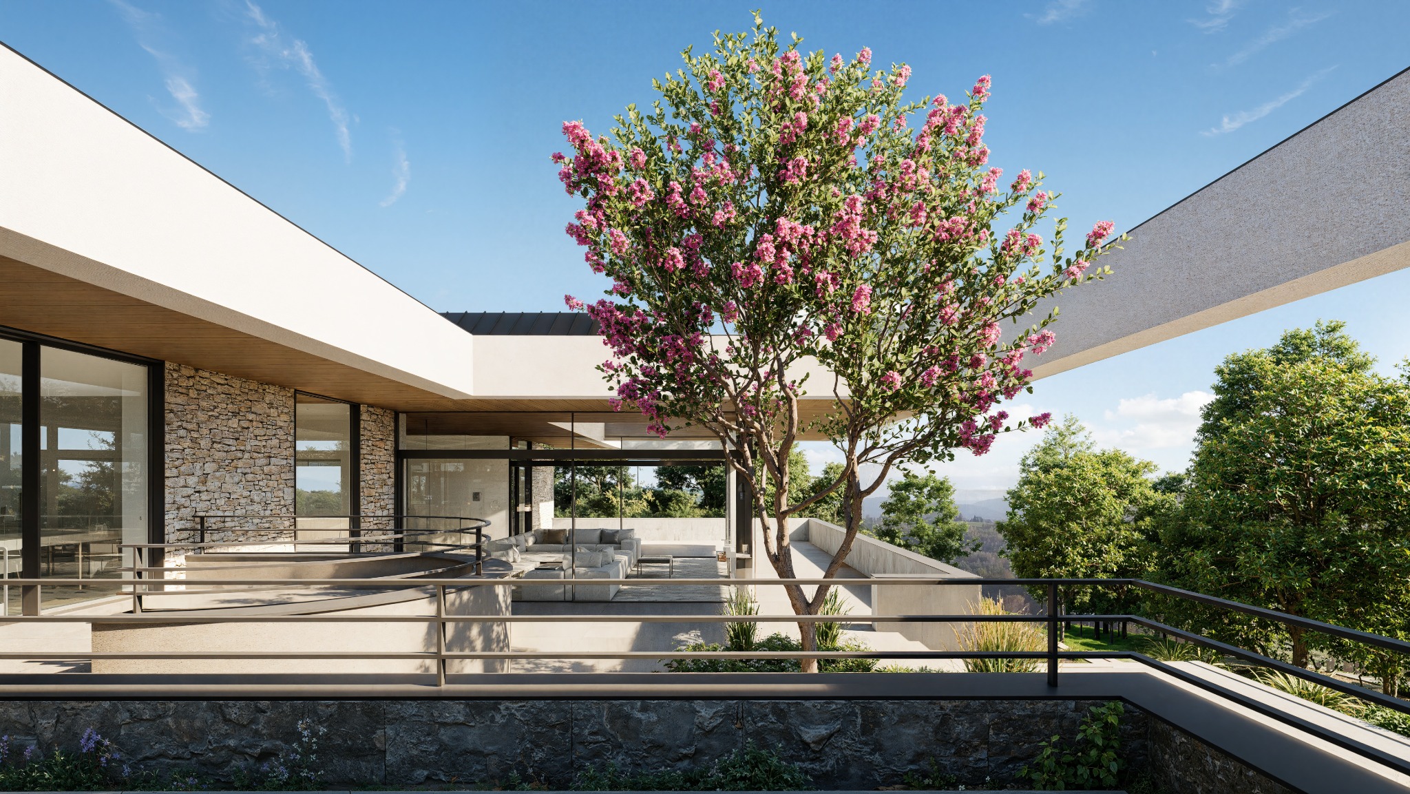 Nowoczesny dom z kamienną elewacją i tarasem, na którym rośnie kwitnące drzewo. Minimalistyczna architektura wkomponowana w zielony krajobraz.