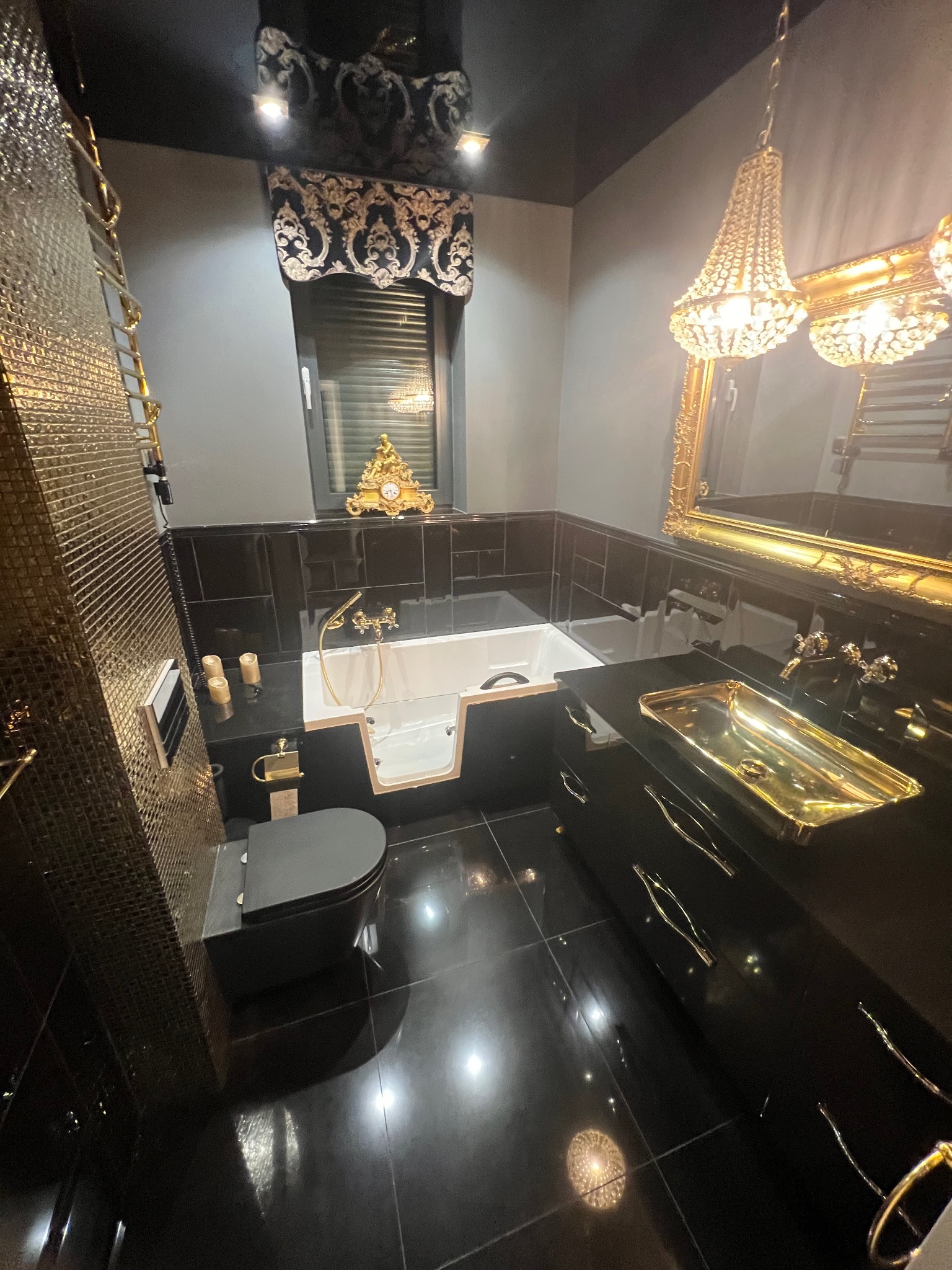 Luksusowa łazienka w czerni i złocie: błyszczące płytki, złota armatura, kryształowy żyrandol i eleganckie dodatki. Nowoczesny design z nutą glamour.