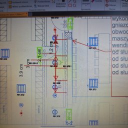 Damian Ławniczek-Wertepny - Plan instalacji elektrycznej biura 1200m2 na ekranie laptopa. Widoczne symbole gniazd, obwodów i wymiary. Użyte narzędzia rysowania i pomiaru w programie.
