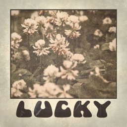 Piotr Dąbrowski - Retro grafika z koniczyną i napisem 'LUCKY' w stylu vintage, imitująca starą odbitkę fotograficzną z efektem ziarna i przetarć. Stylistyka lat 70.