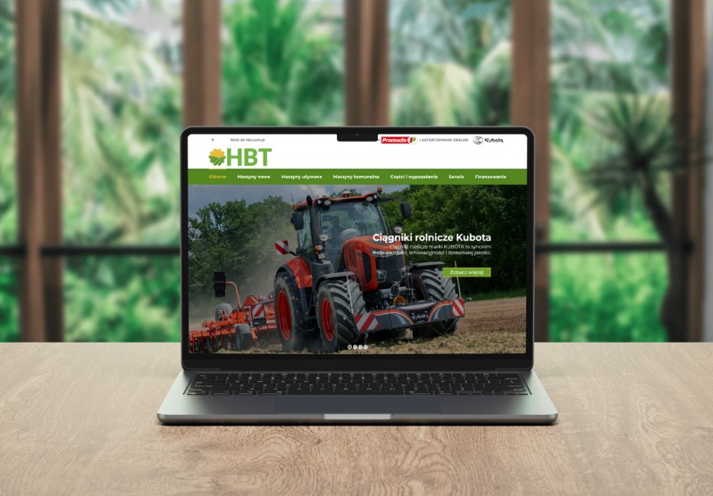 Laptop wyświetla stronę internetową hbt.com.pl/maszyny, prezentującą ciągniki rolnicze Kubota na tle zieleni.