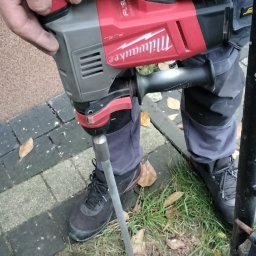 Na zdjęciu widoczny etap wbijania szpilki uziemiającej przy użyciu młota udarowego. Po zakończeniu prac sporządzono protokół potwierdzający prawidłowe wykonanie oraz zgodność z obowiązującymi normami.