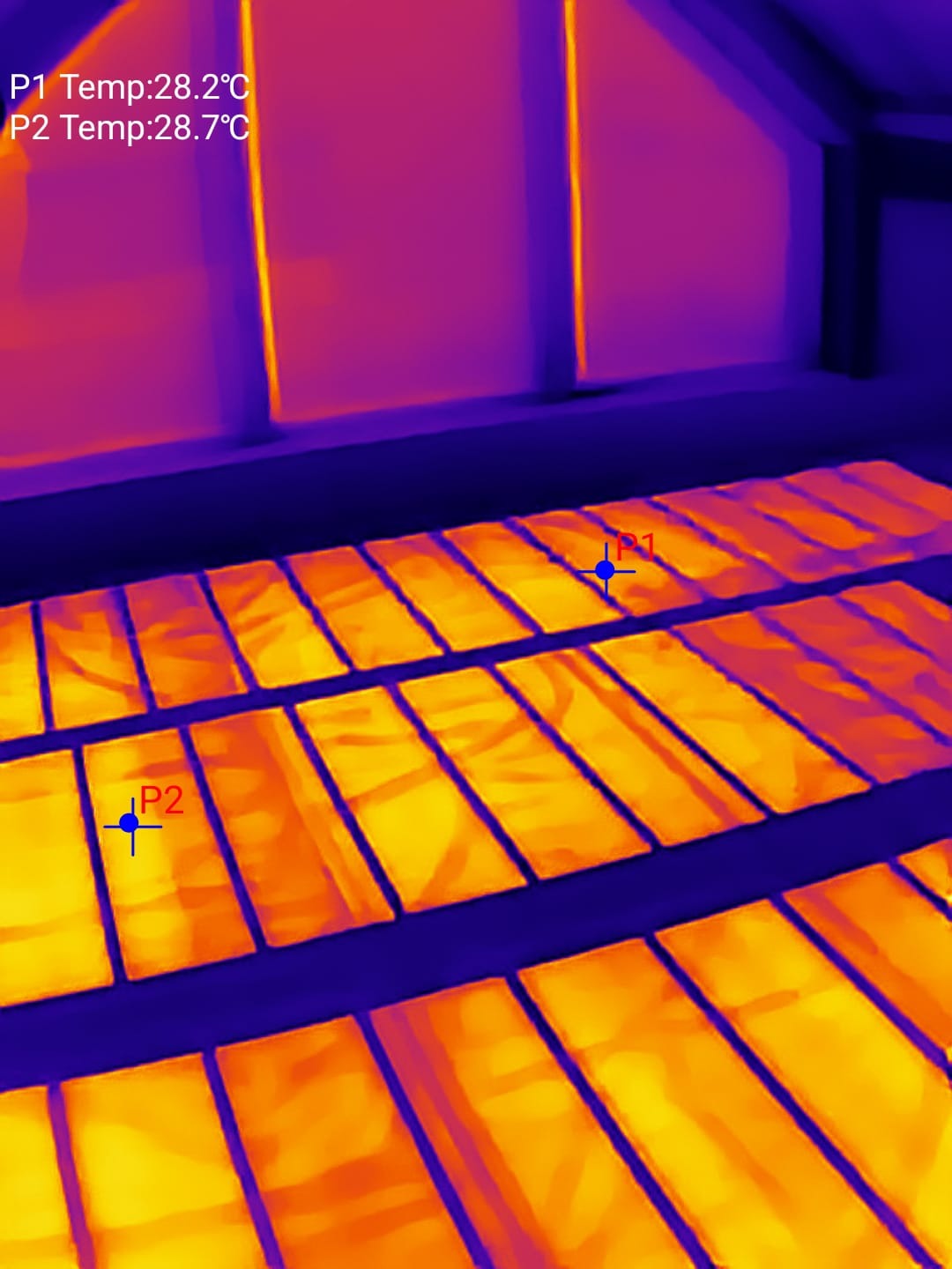 Termowizyjne zdjęcie mat grzewczych podłogowych, ukazujące rozkład temperatur. P1: 28.2°C, P2: 28.7°C. Widoczny fragment poddasza.