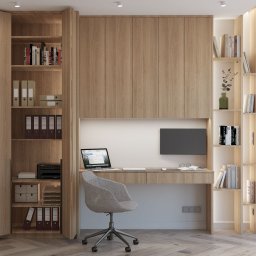 ZMYSŁ WNĘTRZA Architektura Roksana Simińska - Funkcjonalne biuro w domu z drewnianymi szafami, biurkiem podświetlanym LED, szarą krzesłem i parkietem w jodełkę. Laptop i monitor na blacie.
