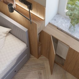 ZMYSŁ WNĘTRZA Architektura Roksana Simińska - Szary pokój dziecięcy z łóżkiem i drewnianą zabudową pod oknem, uzupełnioną o półki i oświetlenie. Widok z góry na wnętrze z rośliną w wazonie.