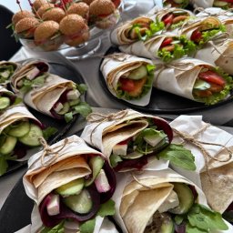 Kamila Dębowska - Dekoracyjne wrapy z warzywami i mini burgery na szklanej paterze, catering na przyjęcie, widok z góry, naturalne światło.