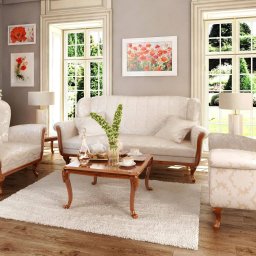 SWARZĘDZKIE PRZEDSIĘBIORSTWO STOLARSKO - TAPICERSKIE RYSZARD TYLKOWSKI - Elegancki salon w Swarzędzu: kremowy, tapicerowany komplet wypoczynkowy (sofa i dwa fotele) na tle okien z widokiem na zieleń. Klasyczny design, drewniane elementy wykończenia.