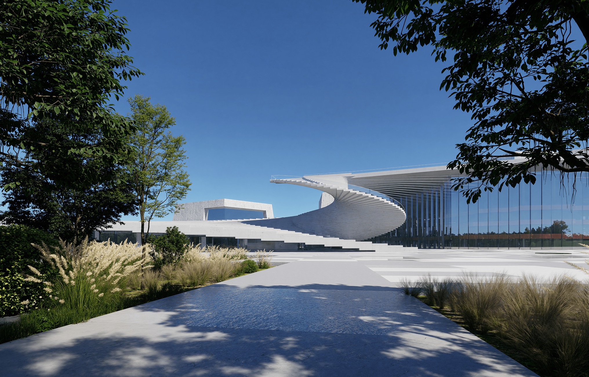 Nowoczesny budynek z zewnętrznymi schodami spiralnymi, otoczony zielenią i ścieżką. Minimalistyczna architektura z dużymi przeszkleniami w słoneczny dzień.