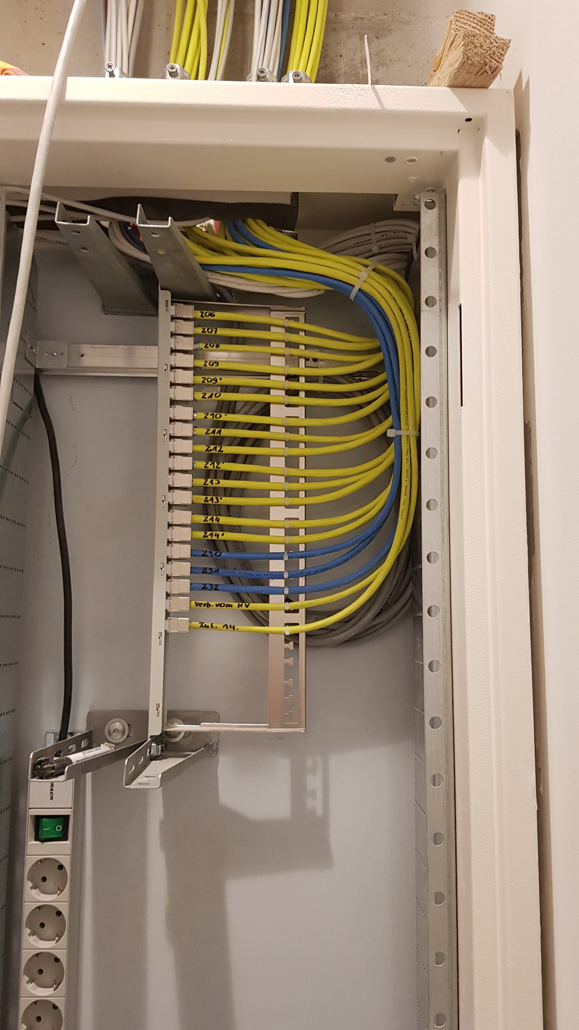 Szczegółowe ujęcie wnętrza szafy elektrycznej z precyzyjnie ułożonymi kablami oznaczonymi numerami, widoczne gniazdka i elementy montażowe. Instalacje elektryczne.