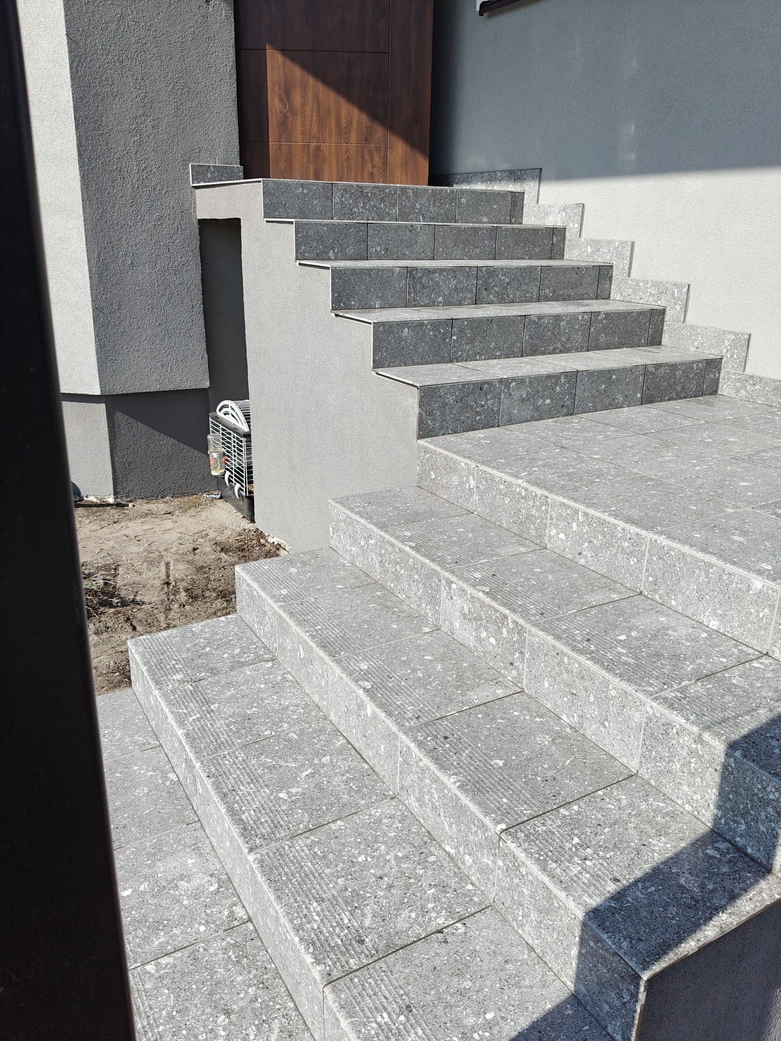 Zewnętrzne schody wyłożone szarą terakotą z widocznym wzorem w Giedlarowej. Nowoczesne wykończenie, estetyczne detale i precyzyjne ułożenie płytek.