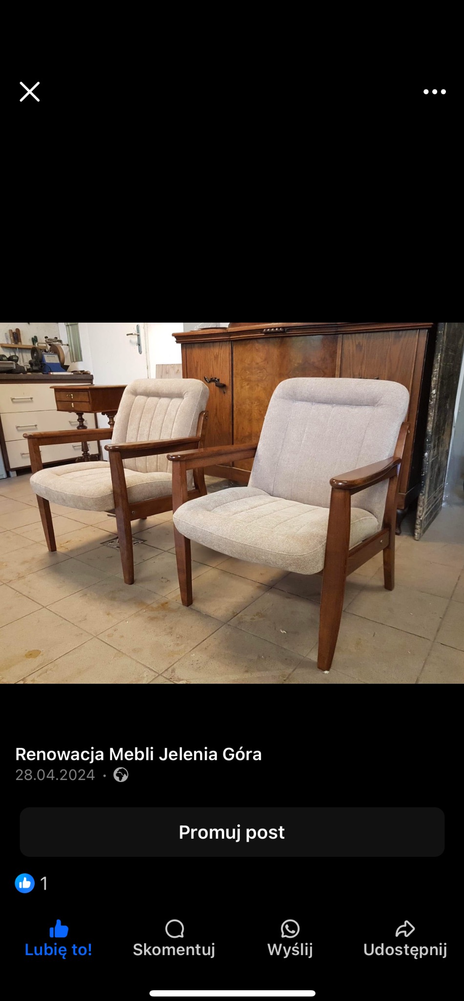 Dwa odnowione fotele z drewnianymi ramami i jasną tapicerką, ustawione na płytkach. W tle szafa i blat, sugerujące warsztat tapicerski.