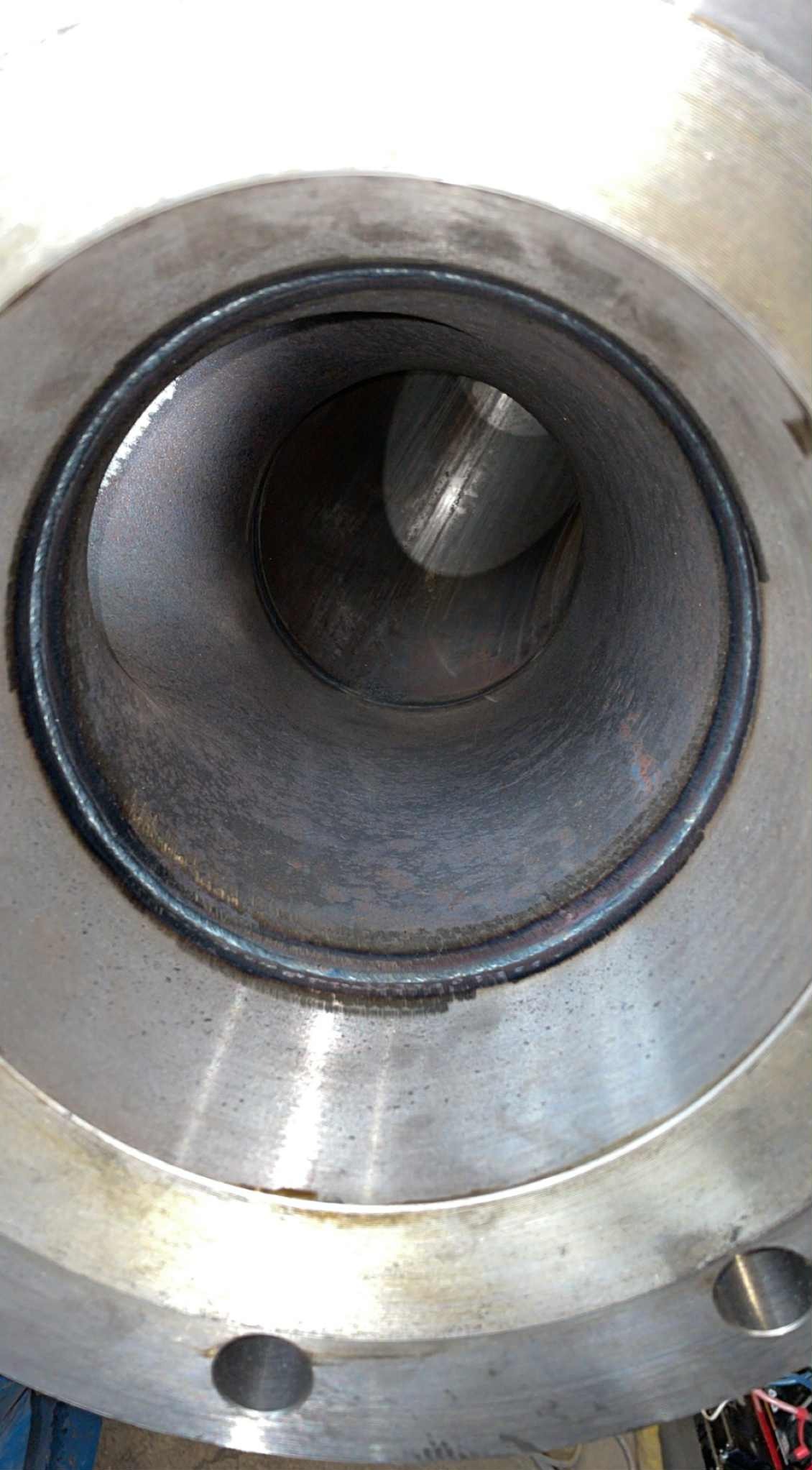 Wnętrze metalowej rury z widocznym spoiną, wykonaną techniką spawania. Widok z bliska, ukazujący precyzję wykonania i jakość połączenia.