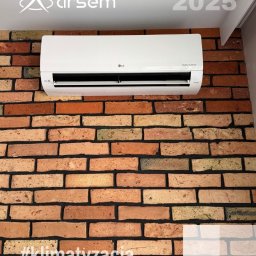 ARSEM sp z o.o. klimatyzacja, chłodnictwo, pompy ciepła, rekuperacja, wentylacja - Biały klimatyzator LG Dual Inverter zamontowany na ścianie z cegły dekoracyjnej w odcieniach brązu i beżu. Widoczne logo firmy Arsem i rok 2025.