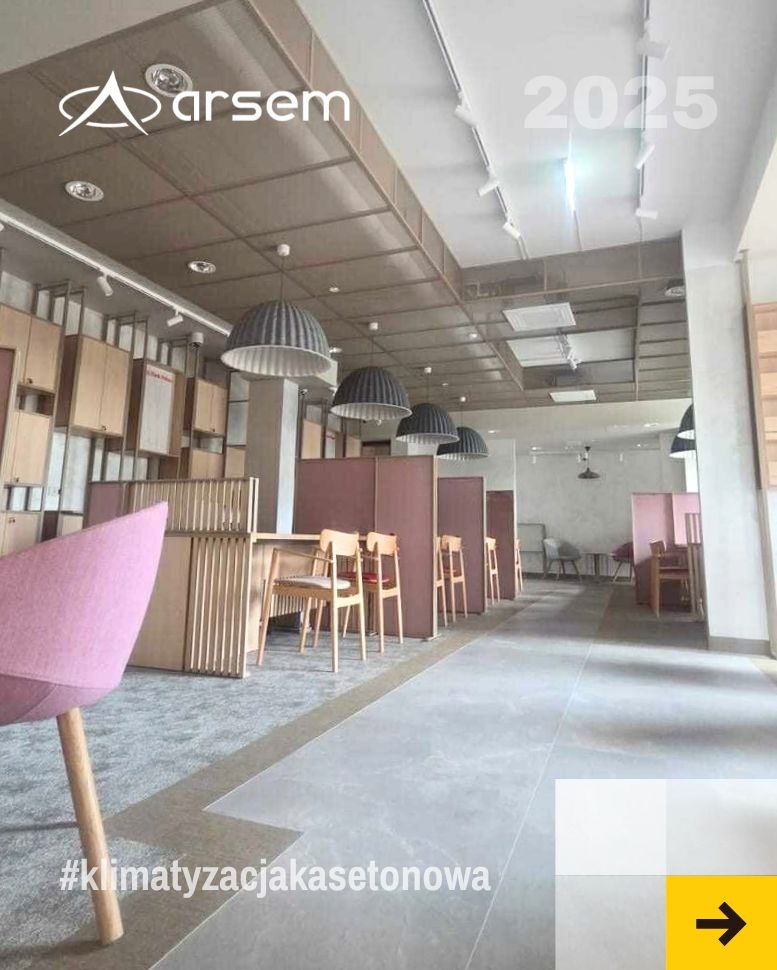 Nowoczesne biuro z widoczną instalacją wentylacyjną pod sufitem, lampami i meblami. Widoczny hashtag #klimatyzacjakasetonowa.