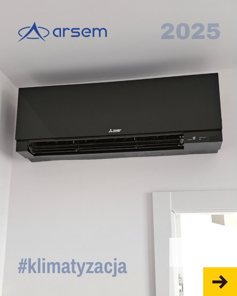 Czarny klimatyzator Mitsubishi Electric zamontowany na ścianie, widoczny z przodu, z logo firmy Arsem i rokiem 2025 w tle. Minimalistyczny design, białe ściany.