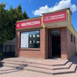 Budynek biura ubezpieczeniowego Sempławski Ubezpieczenia z logo Generali i ofertą ubezpieczeń: życie, podróż, rodzina, dom, firma, auto. Widok z zewnątrz, dzień.