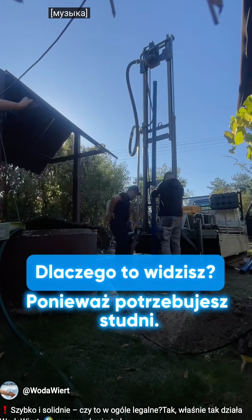 Wiertnica w akcji podczas wiercenia studni głębinowej. Dwóch pracowników obsługuje maszynę. Widoczne rury i sprzęt. Błękitne niebo w tle.