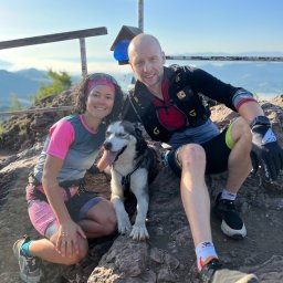 Ewelina zbijowska trener perdonslny - Para z psem husky na szczycie Wysoka w Pieninach, po treningu biegowym. Widok na góry, słoneczna pogoda. Trenerzy biegowi w strojach sportowych.