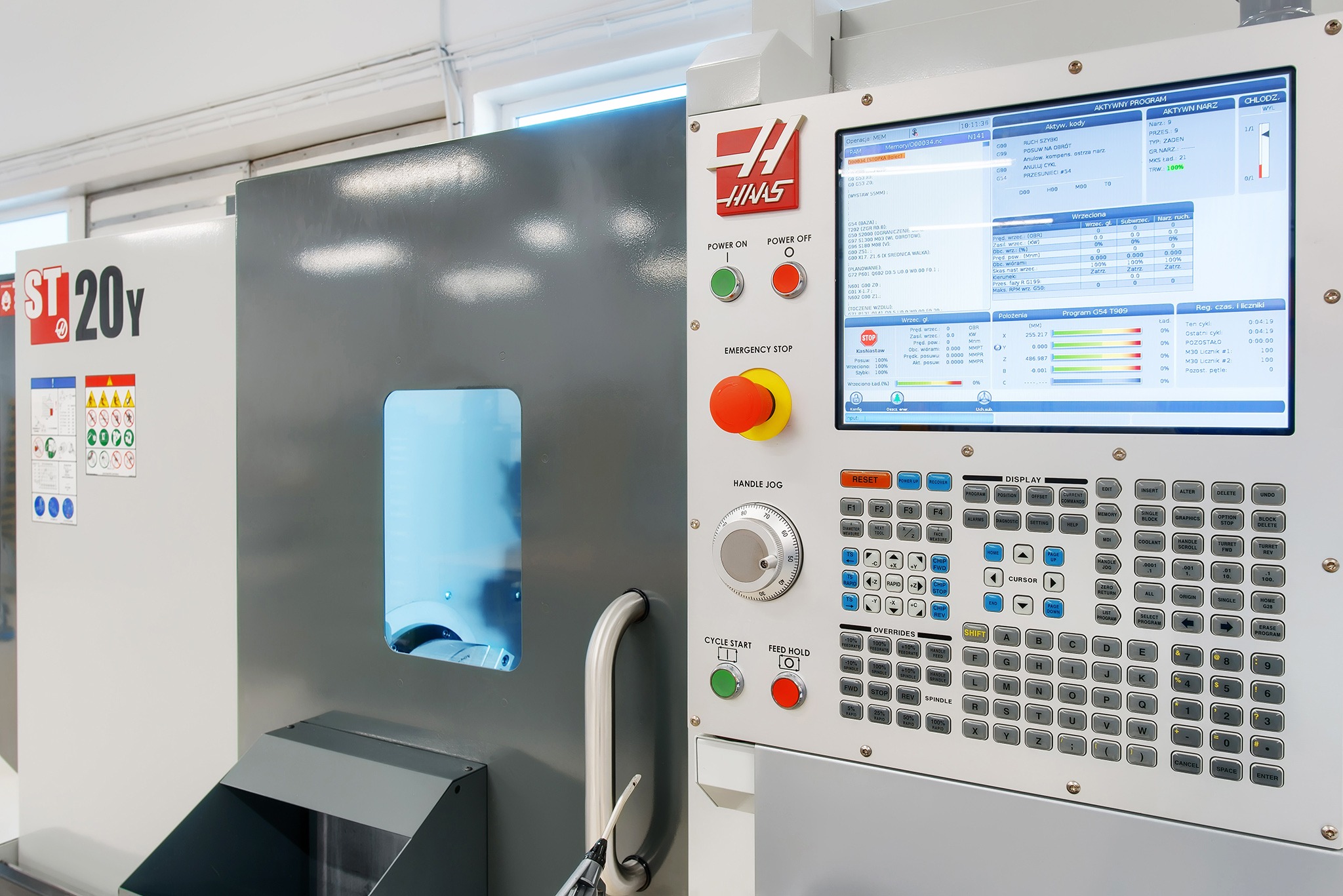 Nowoczesna frezarka CNC Haas ST-20Y z panelem sterowania i widocznym oknem obróbki. Precyzyjne detale, oświetlenie i ergonomiczny design.