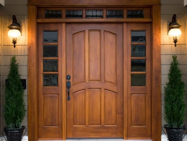 Drewniane drzwi wejściowe z przeszkleniami bocznymi i górnym naświetlem, oświetlone lampami po bokach, Łuków. Klasyczny styl.