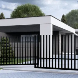 Nowoczesna, czarna brama wjazdowa z pionowych profili, otwierająca się na posesję z minimalistycznym domem. Widoczne trawnik i drzewa w tle. Ujęcie z poziomu gruntu.