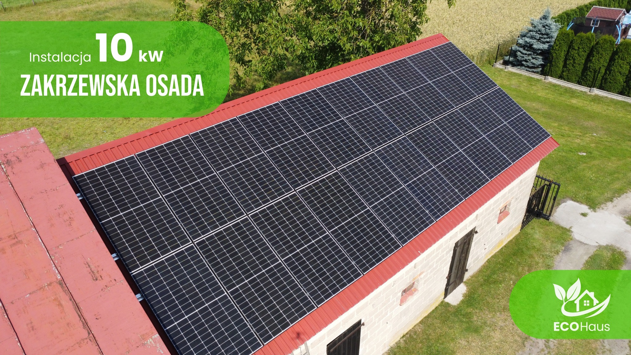 Instalacja fotowoltaiczna 10kW na dachu budynku gospodarczego w Zakrzewskiej Osadzie. Widok z góry, otoczenie zieleni. Logo EcoHaus w prawym dolnym rogu.