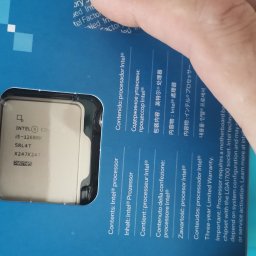 Naprawa Komputerów i Laptopów Serwis Pogotowie Rafał jarosz - Procesor Intel i5-12600K w opakowaniu, widoczny przez okienko. Na pudełku napisy w różnych językach. Dłoń w kadrze. Detaliczny widok na komponent.