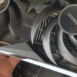 Naprawa Komputerów i Laptopów Serwis Pogotowie Rafał jarosz - Czarny radiator karty graficznej AORUS z dwoma wentylatorami, widoczne żebra chłodzące i fragment dłoni. Detal z bliska, podkreślający konstrukcję chłodzenia.