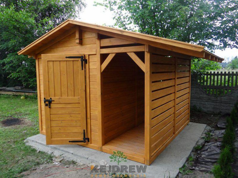 Drewniana altana ogrodowa z otwartymi drzwiami, widoczne poziome listwy na ścianie bocznej i betonowa podstawa.