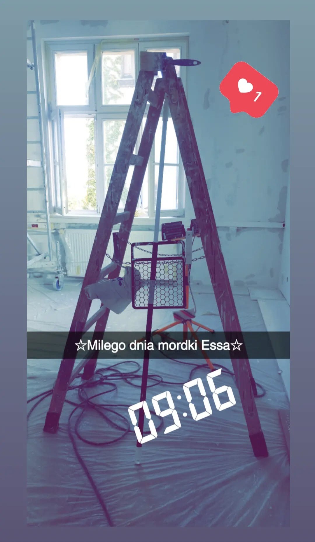 Wnętrze w trakcie prac: drabina malarska, lampa halogenowa, zabezpieczona folią podłoga. Ściany z widocznymi śladami szpachlowania. Okno w tle.