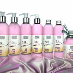 Rząd siedmiu butelek kosmetyków Bingo Silk Pure, od lewej: płyn do mycia twarzy i szyi, mydło do rąk, mydło do stóp, płyn do higieny intymnej, szampon odżywczy, mleczko pod prysznic, regenerujący...
