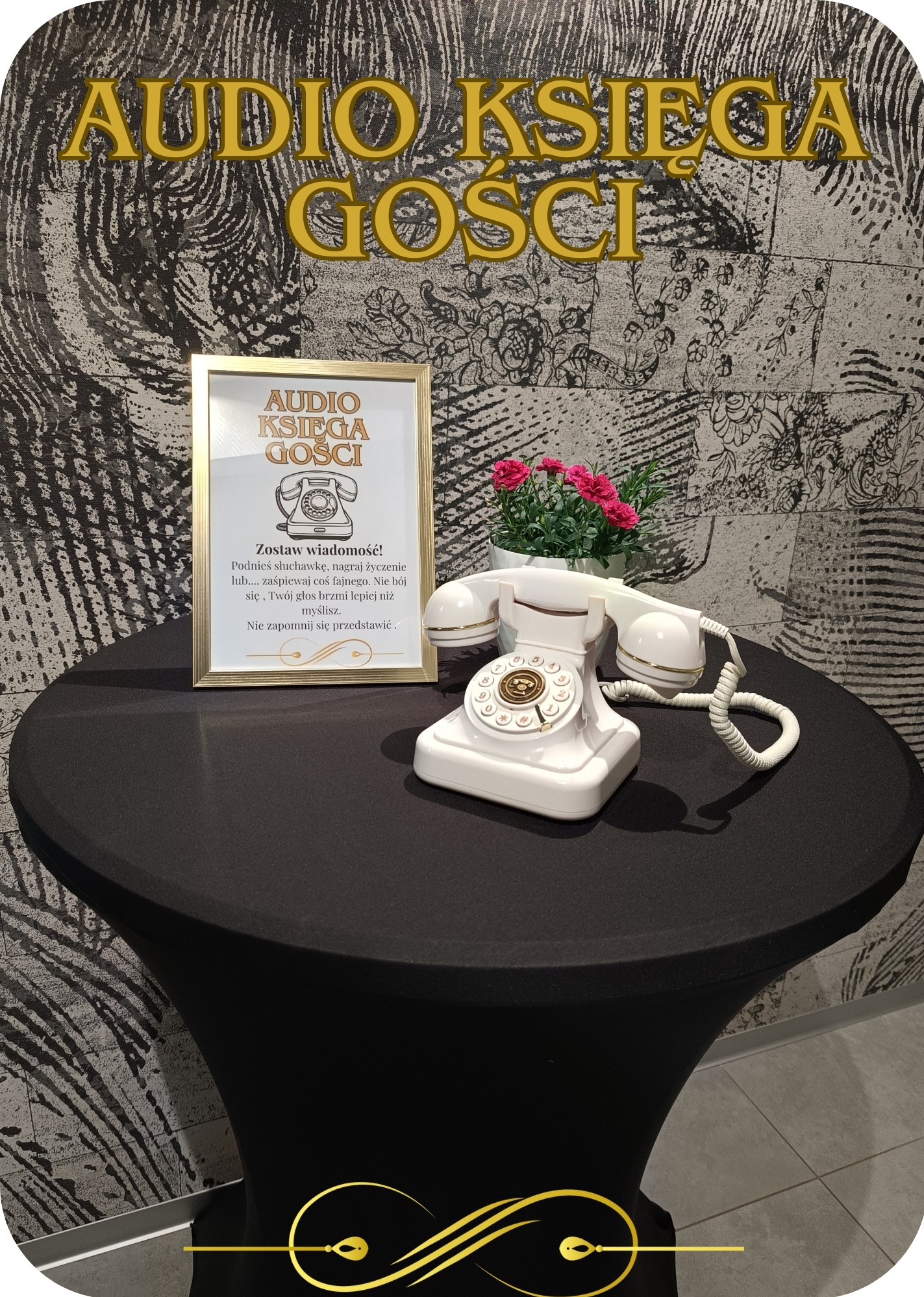 Audio księga gości: biały telefon retro na czarnym stoliku, obok ramka z instrukcją i kwiaty. Dekoracja na imprezę, pamiątka głosowa z życzeniami.