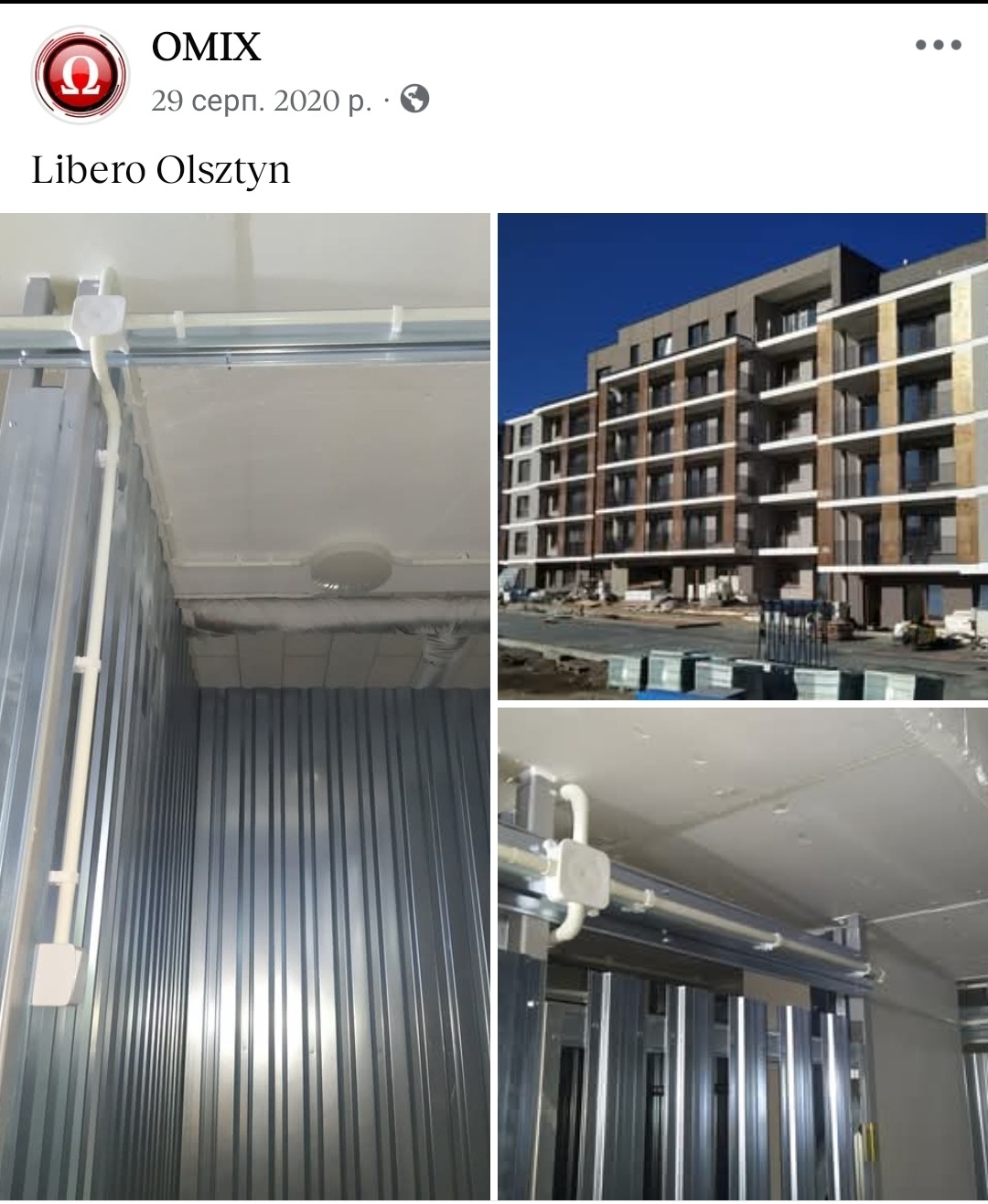 Białe rury i puszki instalacji elektrycznej zamontowane w surowym wnętrzu budynku w trakcie budowy. Na zewnątrz widoczny budynek wielorodzinny w budowie.