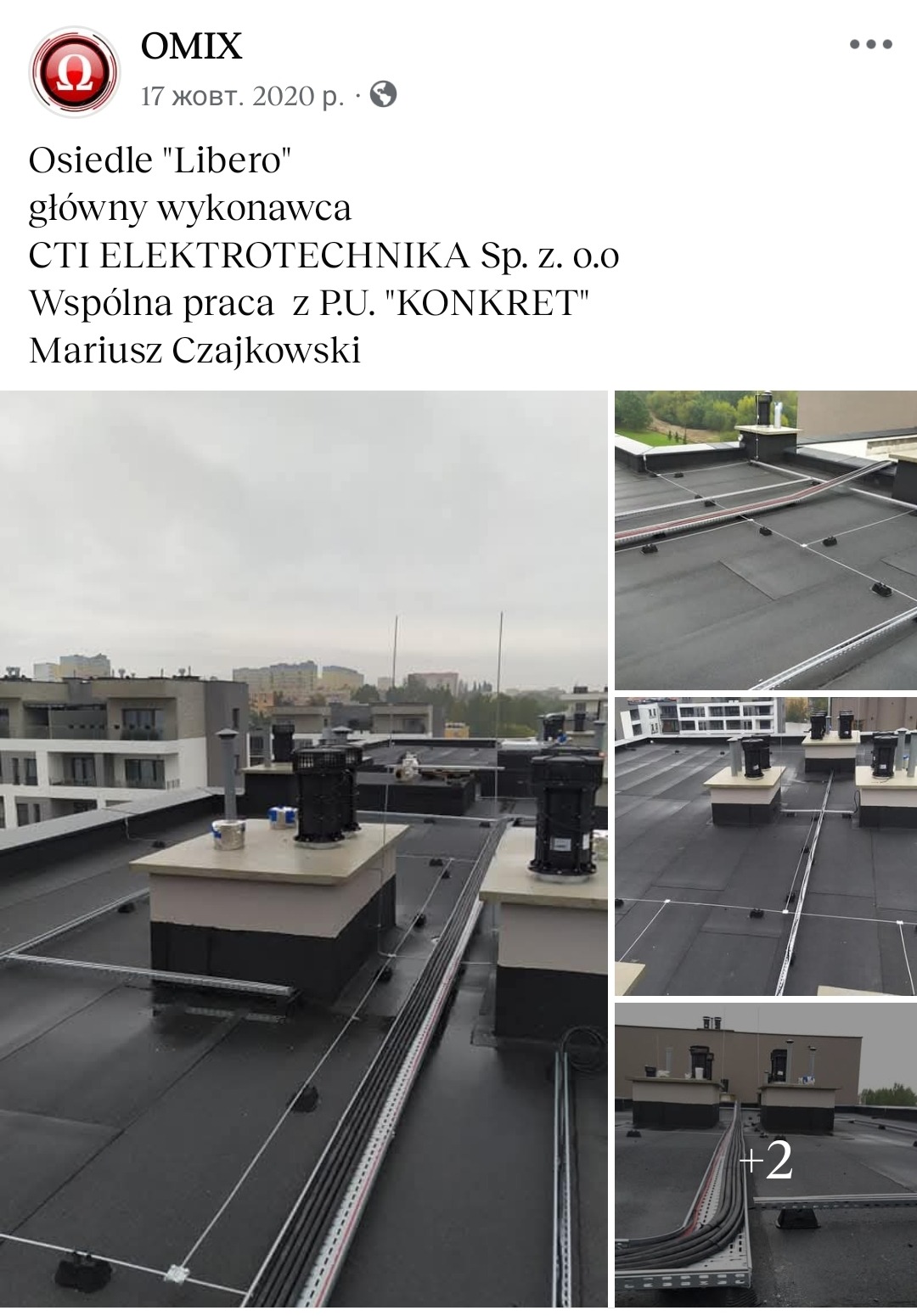 Instalacja odgromowa na dachu budynku wielorodzinnego. Widoczne przewody i elementy mocujące. Tło stanowi zabudowa miejska pod pochmurnym niebem.