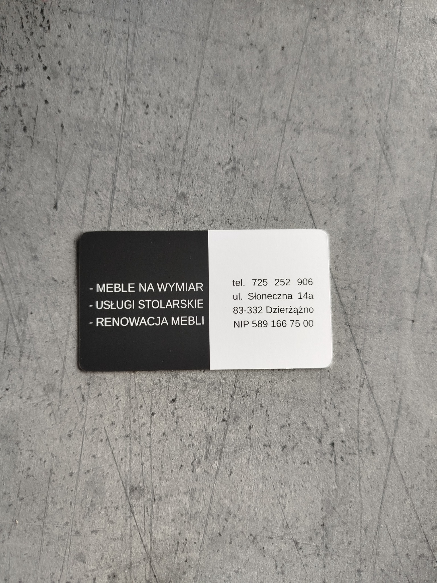 Wizytówka firmy oferującej meble na wymiar, usługi stolarskie i renowację mebli. Na wizytówce dane kontaktowe: numer telefonu i adres.