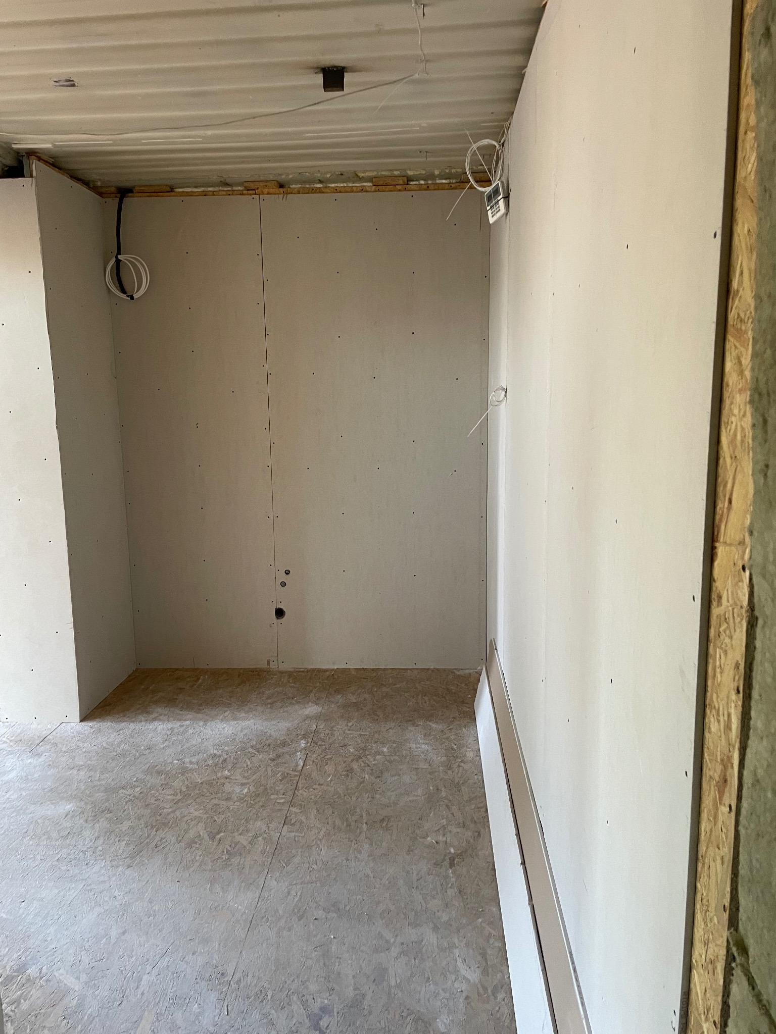 Montaż płyt karton gips w Kartuzach. Widoczne ściany z płyt, instalacja elektryczna i surowa podłoga z płyty OSB. Etap prac wykończeniowych.