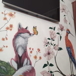 Gaga - Mural na ścianie z motywem lisa z motylem, żurawia i kwiatów magnolii, podwieszony telewizor. Malarstwo artystyczne w pokoju dziecięcym.
