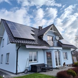 Gaga - Jasny dom jednorodzinny z panelami słonecznymi na dachu, widok z ogrodu w słoneczny dzień. Na balkonie widoczna antena satelitarna.