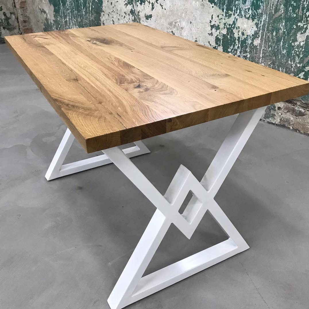 Stół z blatem z jasnego drewna i białymi, metalowymi nogami o geometrycznym kształcie. Wykonanie na zamówienie we Wrocławiu.