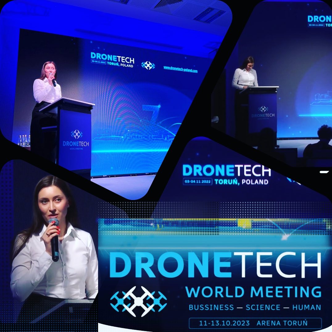 Prelegentka na tle ekranu z logo Dronetech Toruń, prezentująca podczas konferencji. Ujęcie z bliska, widoczny mikrofon i podium. Konferencja biznesowa.