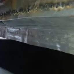 Detal podwozia samochodu po spawaniu, widoczne ślady spaw&oacute;w i napraw blacharskich. Metaliczna powierzchnia z widocznymi nier&oacute;wnościami i śladami obr&oacute;bki.