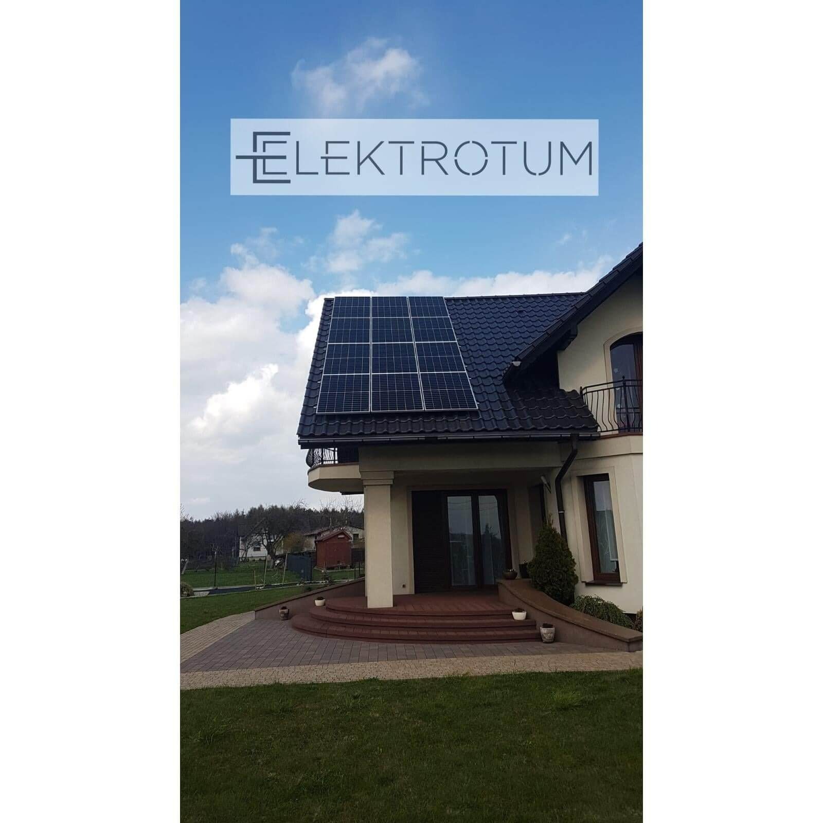 Dom jednorodzinny z panelami słonecznymi na dachu, widok z poziomu trawnika. Na niebie widoczne białe obłoki. U góry logo firmy.