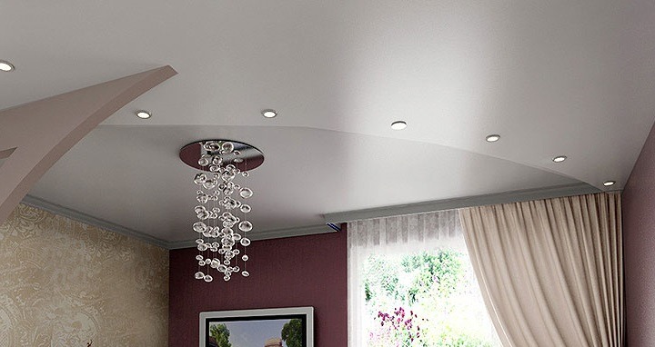 Biały, podwieszany sufit napinany z oświetleniem punktowym i dekoracyjnym żyrandolem w salonie. Realizacja w Łodzi. Nowoczesny design.