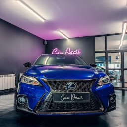 COLOR DETAIL SPÓŁKA Z OGRANICZONĄ ODPOWIEDZIALNOŚCIĄ - Błyszczący, niebieski Lexus po detailingu, z neonowym logo 'Color Detail' w tle, podkreślającym profesjonalizm usługi. Widoczne odbicia światła na lakierze.
